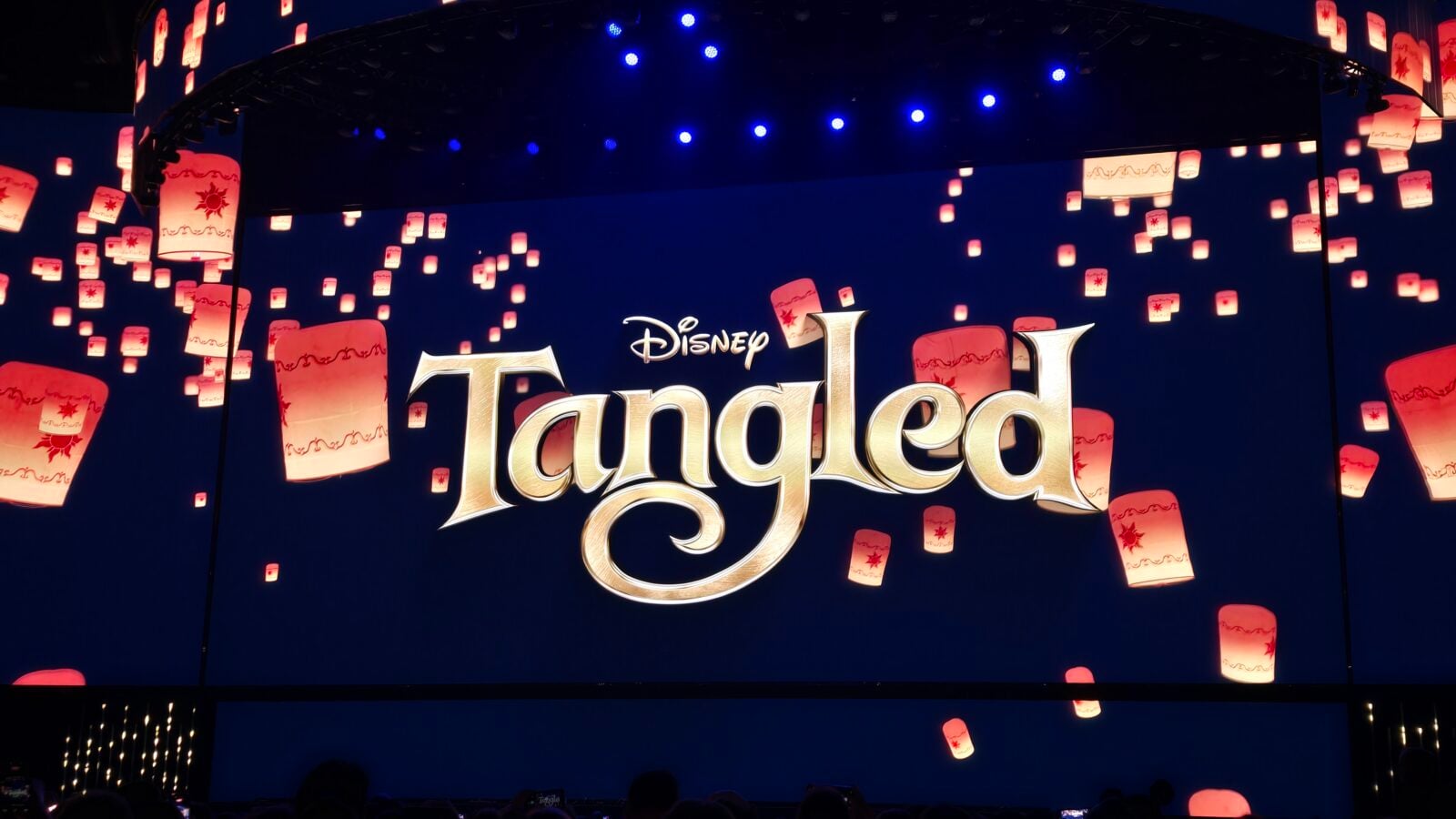 Disney Tangled stage backdrop with glowing lanterns and the logo on a dark blue background