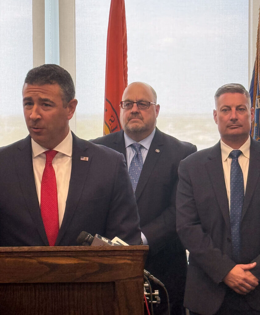 FBI Special Agent in Charge Michael Ratta, left, along with  Long Beach Deputy Inspector Stefan Chernaski and Long Beach Police Commissioner Richard DePalma announced the recovery of more than 20 guns and a "large amount" of cocaine, fentanyl, ecstasy, heroin and more than $100,000 in cash.