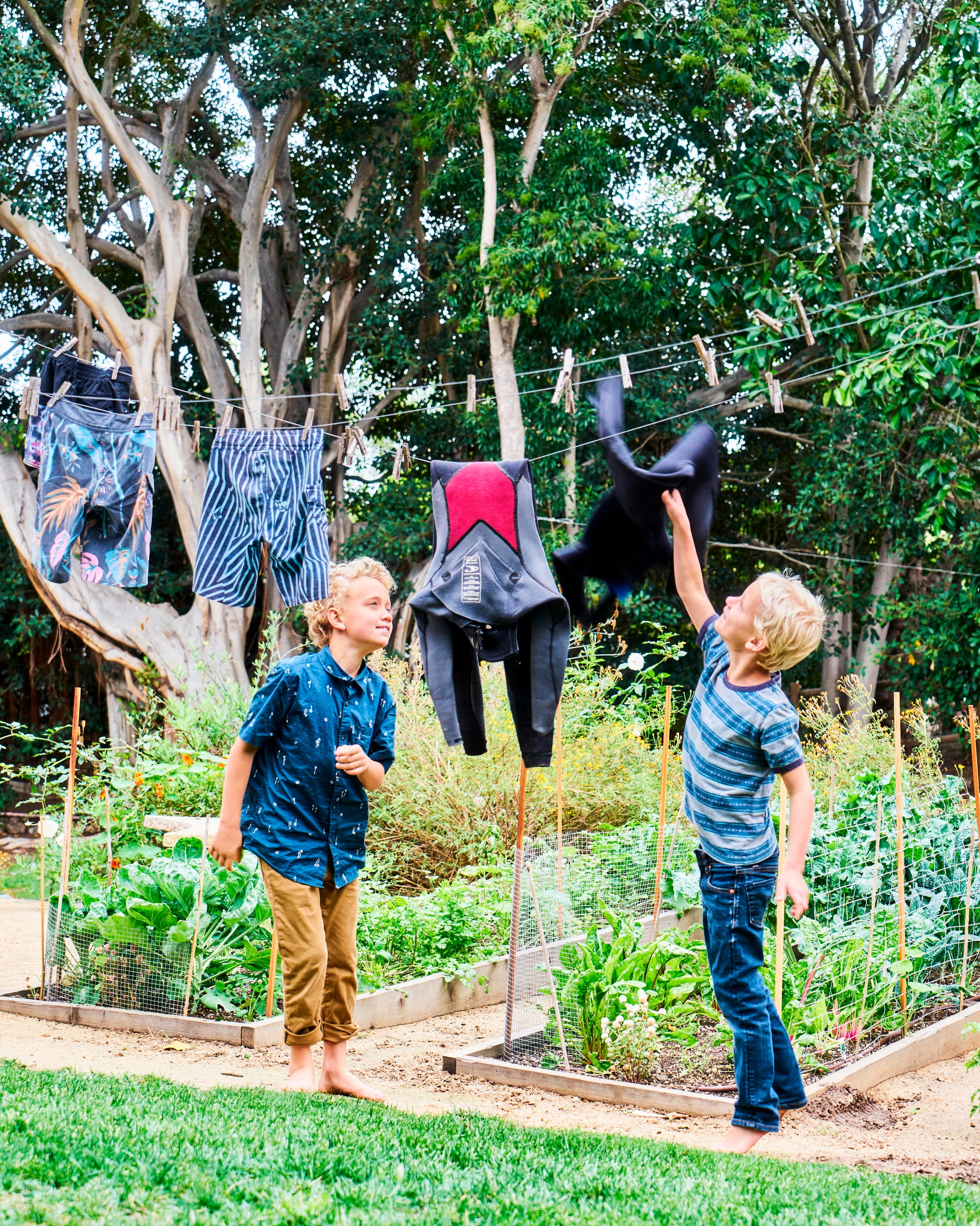 two boys playing in front of garden beds two boys playing in front of garden beds