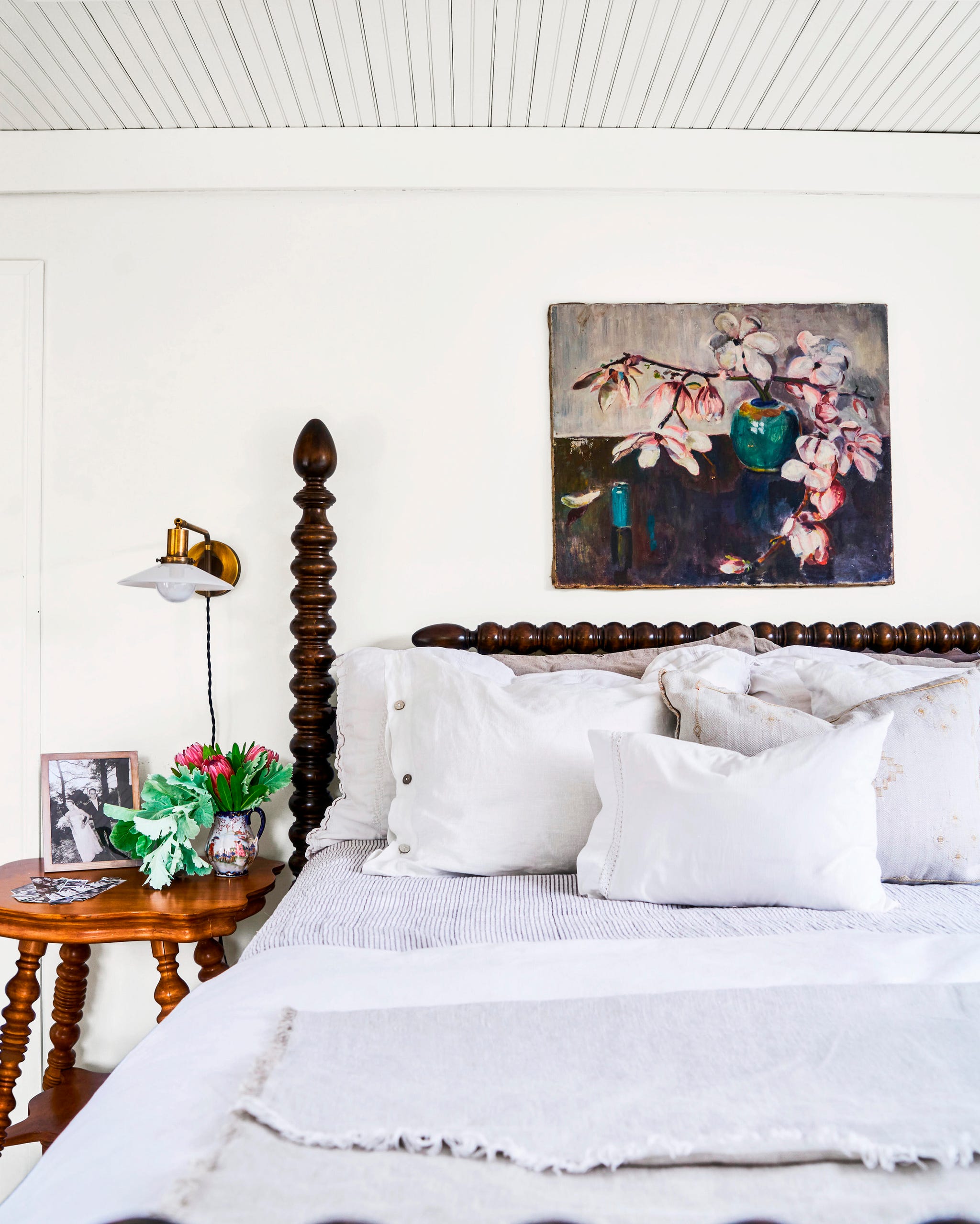 bedroom with spindle bed with white bedding a painting of flowers above it bedroom with spindle bed with white bedding a painting of flowers above it