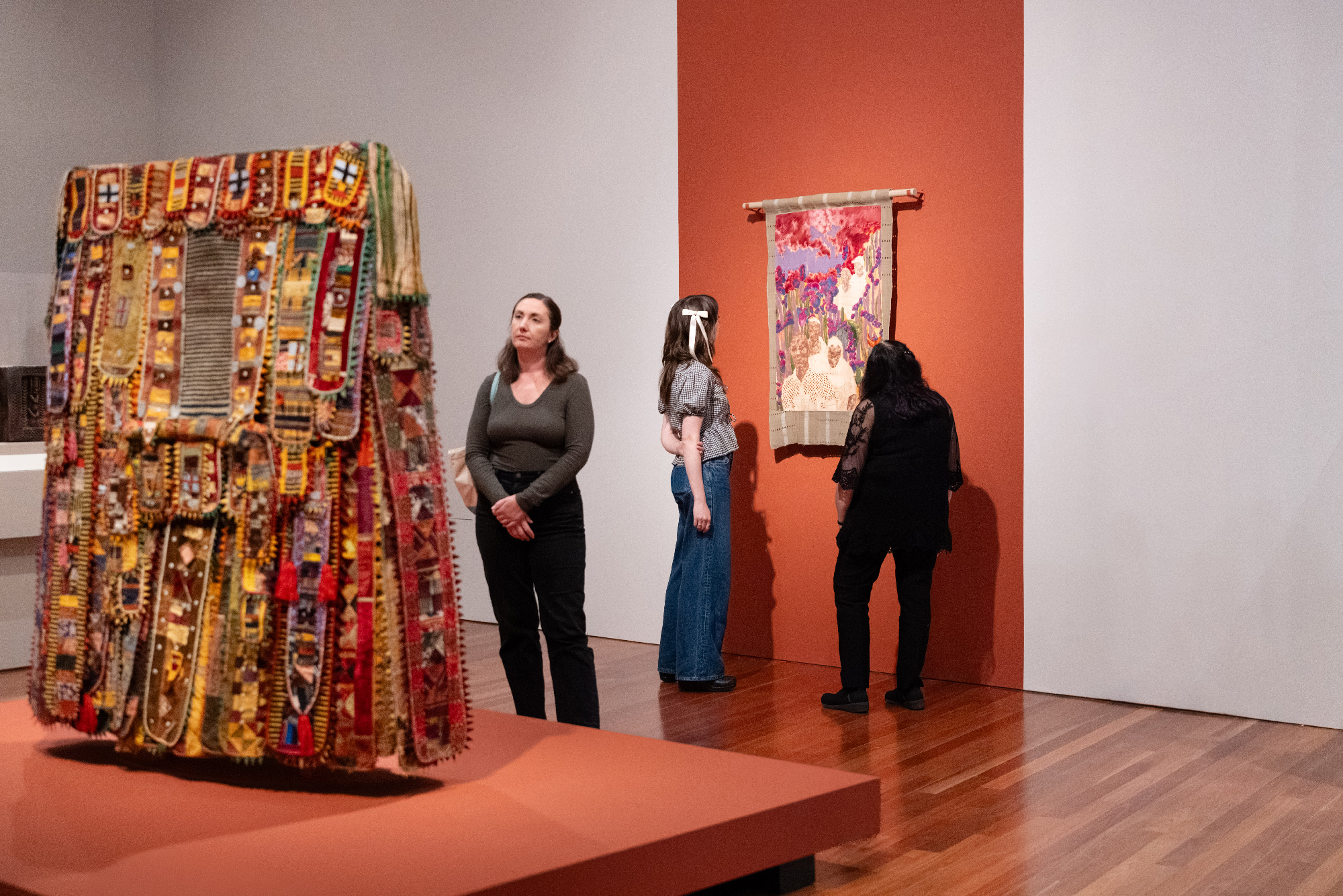 multicolored object in gallery display, painting hanging behind