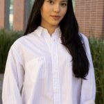 Kayla Luke Colon in a button-up white top.