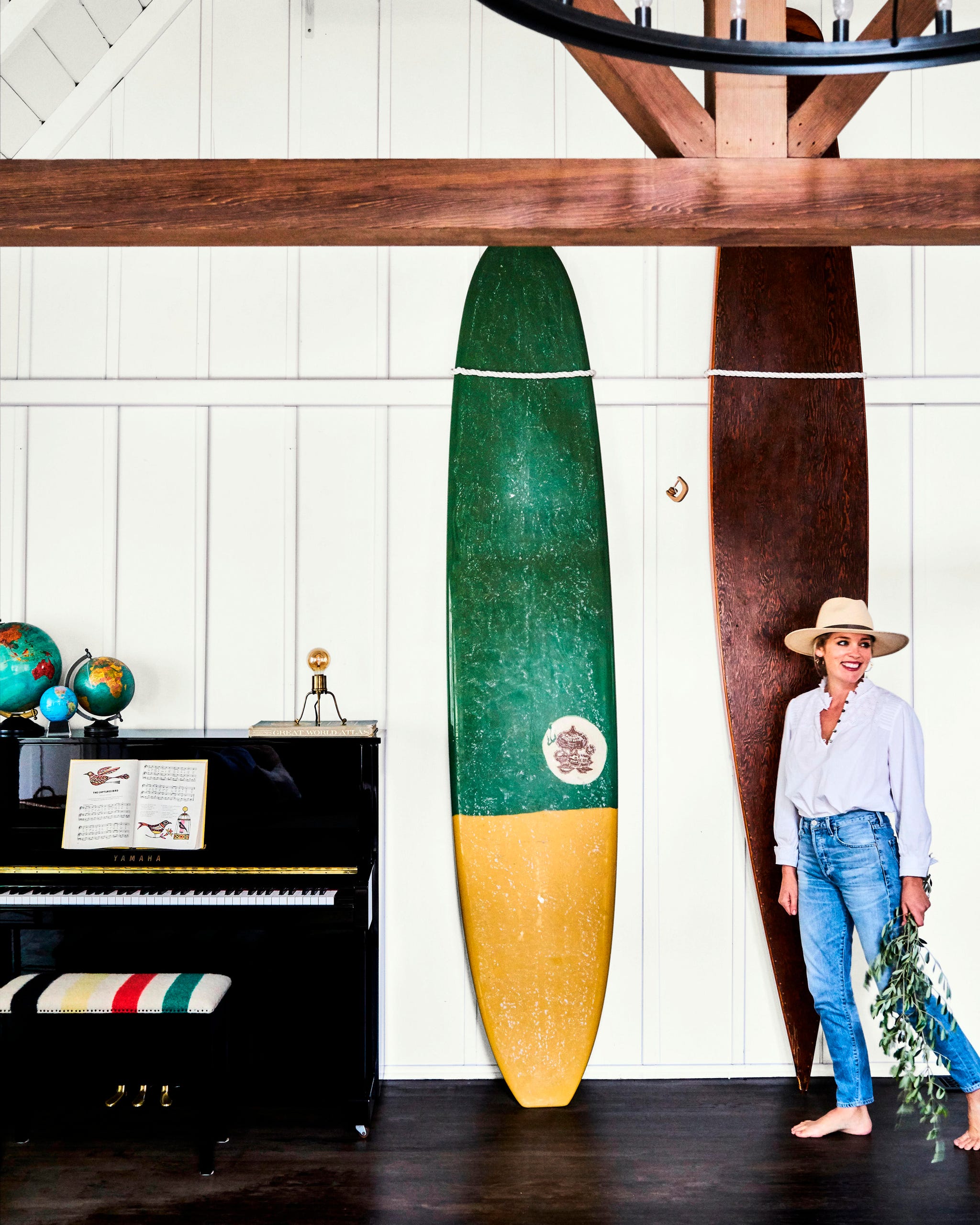 room with two large surfboards against the wall and a black upright piano room with two large surfboards against the wall and a black upright piano
