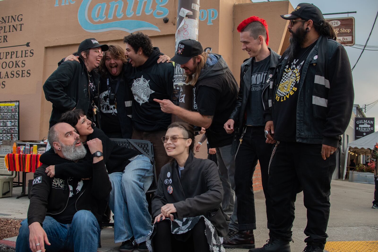 A group of people, all of them dressed in black, talk with one another as they prepare to pose for a photo