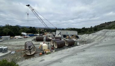 California just finished shoving an 8-foot boring machine 347 feet under a lake with nothing to brace against, coming out through the reservoir floor with the water still sitting on top, and the dam above it is now coming down for a rebuild