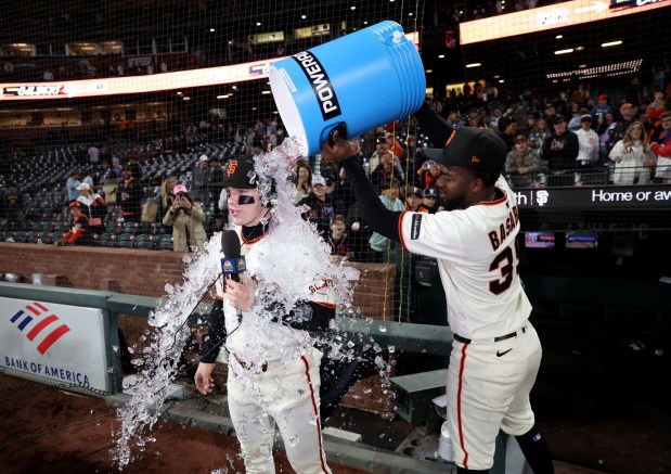 San Francisco Giants' Drew Gilbert #0 is doused with water and ice by teammate Osleivis Basabe #39 after their 5-0 MLB win against the Cincinnati Reds at Oracle Park in San Francisco, Calif., on Monday, August 24, 2026. (Jane Tyska/Bay Area News Group)