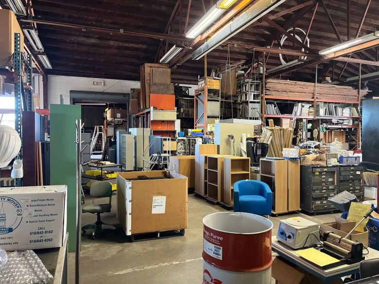 A view of a warehouse that is crowded with disorganized office supplies