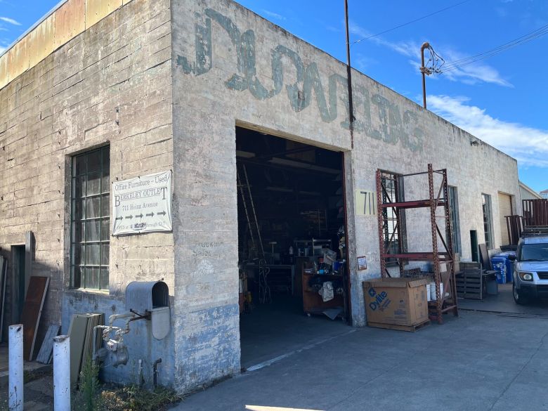 A gray warehouse with a large open door