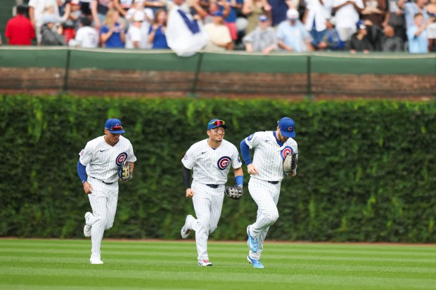 Tyrone Taylor, from left, Seiya Suzuki and Ian Happ run in from the outfield after the Cubs defeated the Dodgers 7-6 on Wednesday, Aug. 5, 2026, at Wrigley Field. (Eileen T. Meslar/Chicago Tribune)