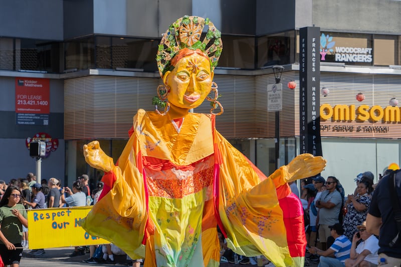 Inspired by Maya, the mother of Buddha, the golden puppet presented by the Little Tokyo Historical Society features local community businesses and organizations written on her headpiece.