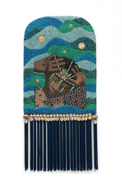 A beaded artwork features a figure holding their face amid wavy patterns in blue and green tones, adorned with shells and hanging dark blue tassels at the bottom.