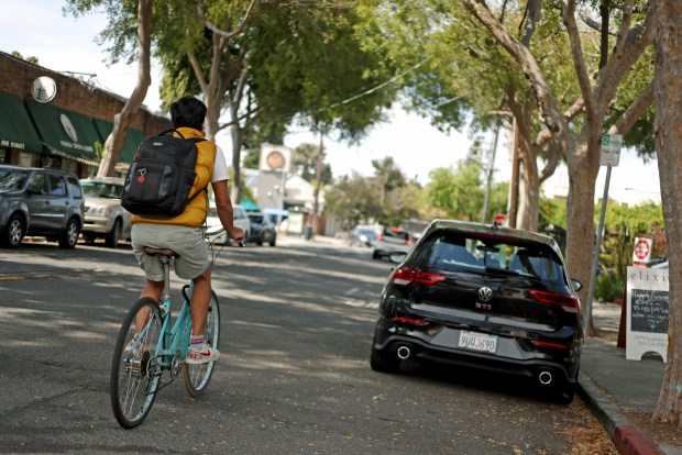 A cyclist rides in a bike lane along Hopkins Street on Thursday, Aug. 13, 2026, in Berkeley, Calif. The city of Berkeley is looking at removing over a hundred parking spaces along Hopkins Street for a new bike lane project. (Aric Crabb/Bay Area News Group)