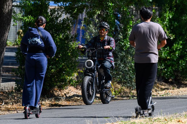 An e-bike rider passes two people riding electric scooters along the Iron Horse Trail in Pleasant Hill, Calif., on Thursday, July 2, 2026. (Jose Carlos Fajardo/Bay Area News Group)