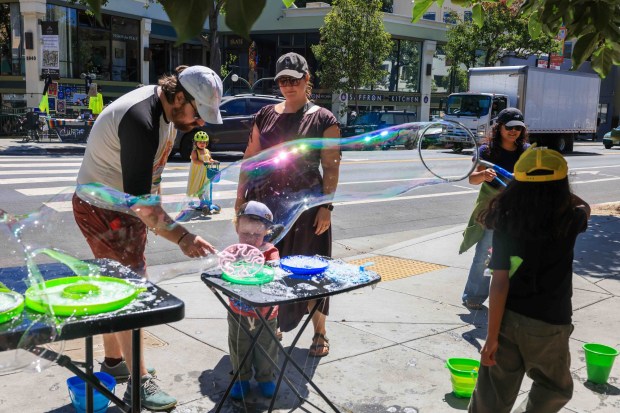 Community members make giant bubbles during the Rockridge Rock-N-Stroll event along College Avenue in Oakland, Calif., on Saturday, Aug. 22, 2026. (Ray Chavez/Bay Area News Group)