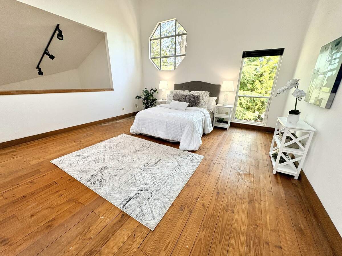 The primary bedroom is loft style, and looks down over the living room.