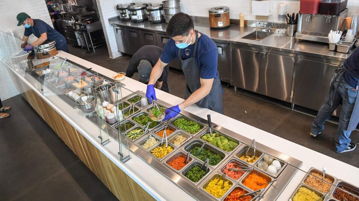 Employees at Butterfish on Friant Road near Fresno Street prepare poke bowls after opening with a new menu in this file photo from Nov. 4, 2020. The restaurant is now offering hot bowls such as teriyaki chicken and beef with fried rice and other toppings.