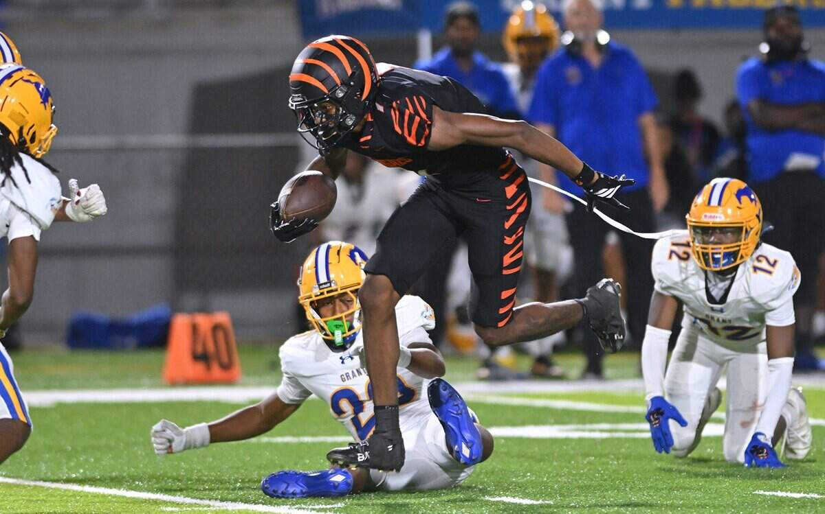 Central East's Relando Jefferson, center, breaks through Gran High tackles in week 2 action Friday night, Aug. 28, 2026 in Fresno.