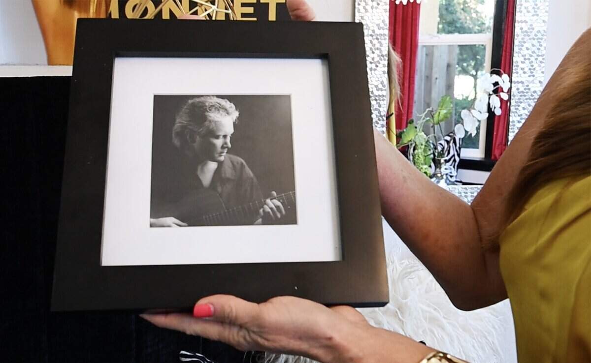 Pianist Gina Lenee holds a framed photograph of Jeff Hall, guitarist, producer, former owner of Maximus Media and former owner of the Harmony House, Lenee's vision for a home and central gathering place for musicians and artists along North Van Ness Ave. Photographed Thursday, July 31, 2026 in central Fresno.