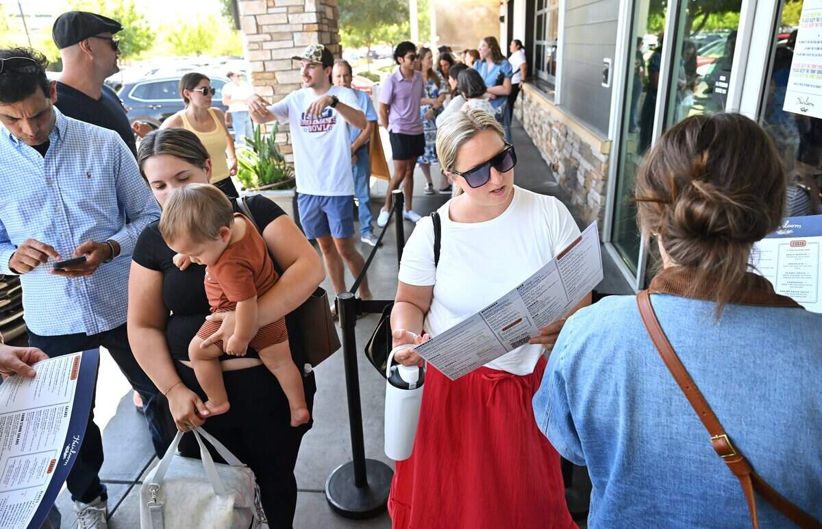 Emily Nazaroff, center, looks over the menu as she stands in line at north Fresno's Heirloom restaurant in the Park Crossing shopping center, Friday, Aug. 21, 2026 in Fresno.