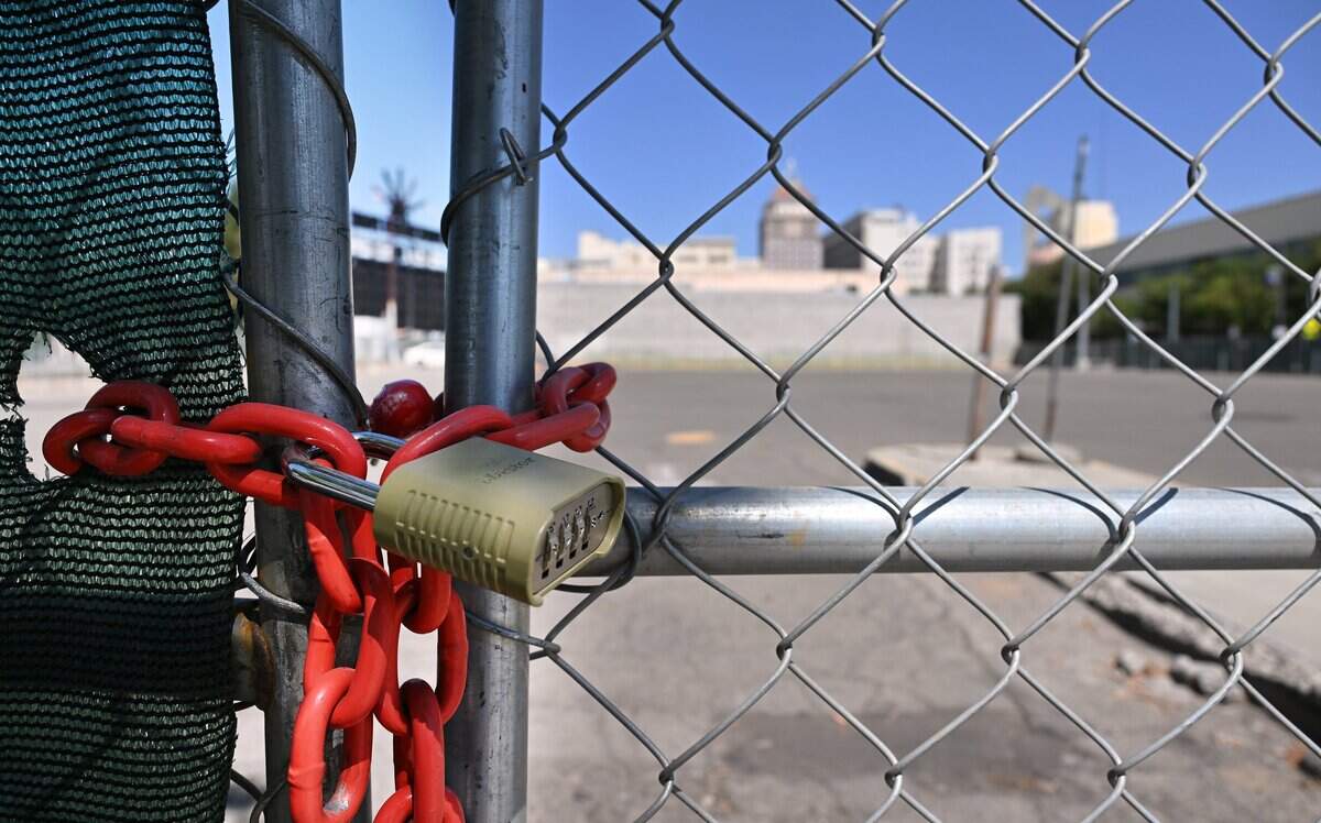 A lock placed along fencing at the empty lot at Inyo and Fulton streets, future site of The Park at South Stadium apartments is seen Aug. 5, 2026 in downtown Fresno.