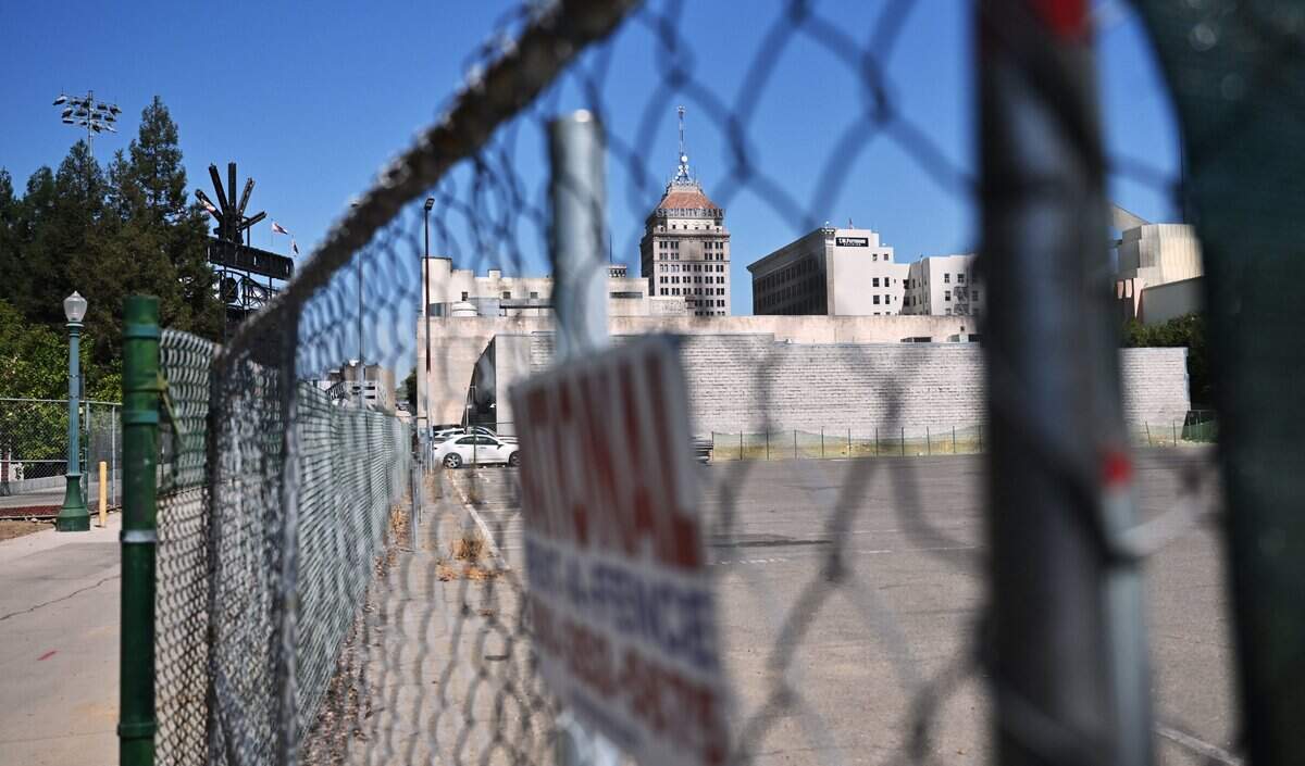 Fencing blocks off the empty lot at Inyo and Fulton streets, future site of The Park at South Stadium apartments, with Chukchansi Park seen to the left in the far background, is seen Aug. 5, 2026 in downtown Fresno.