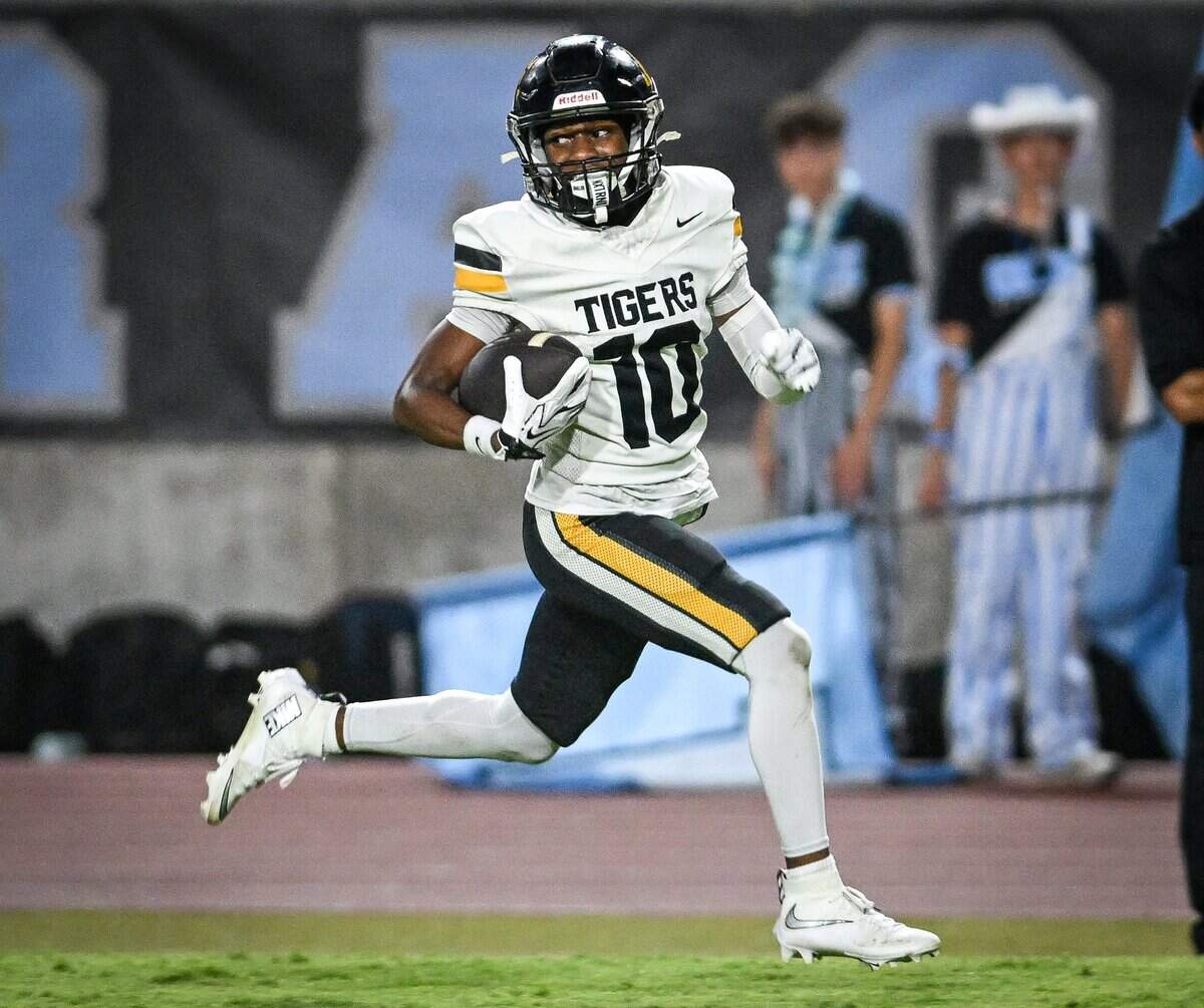 Edison's Corey Thomas looks back while taking the ball in for a touchdown after intercepting a Clovis North pass at Veterans Memorial Stadium in Clovis on Thursday, Aug. 27, 2026.