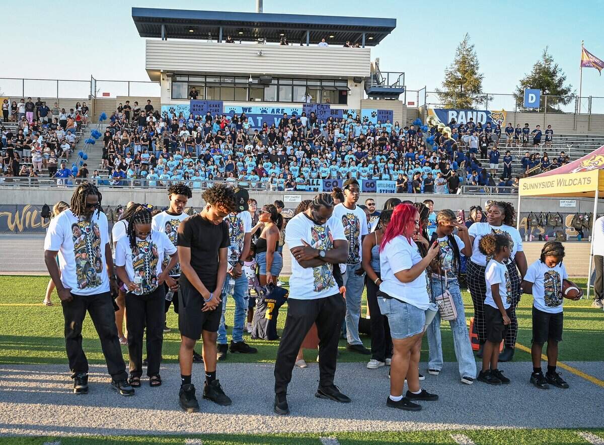 Family members and friends of Robert Peele III, A Sunnyside High School student who was struck and killed by a vehicle on his way to football practice last month, are joined on the football field by the Sunnyside High School community in a moment of silence before the start of the Wildcats opener on Thursday, Aug. 20, 2026.