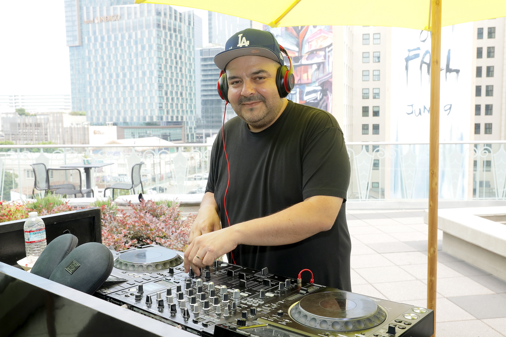 A Mexican DJ smiles as he looks up from behind the decks. 