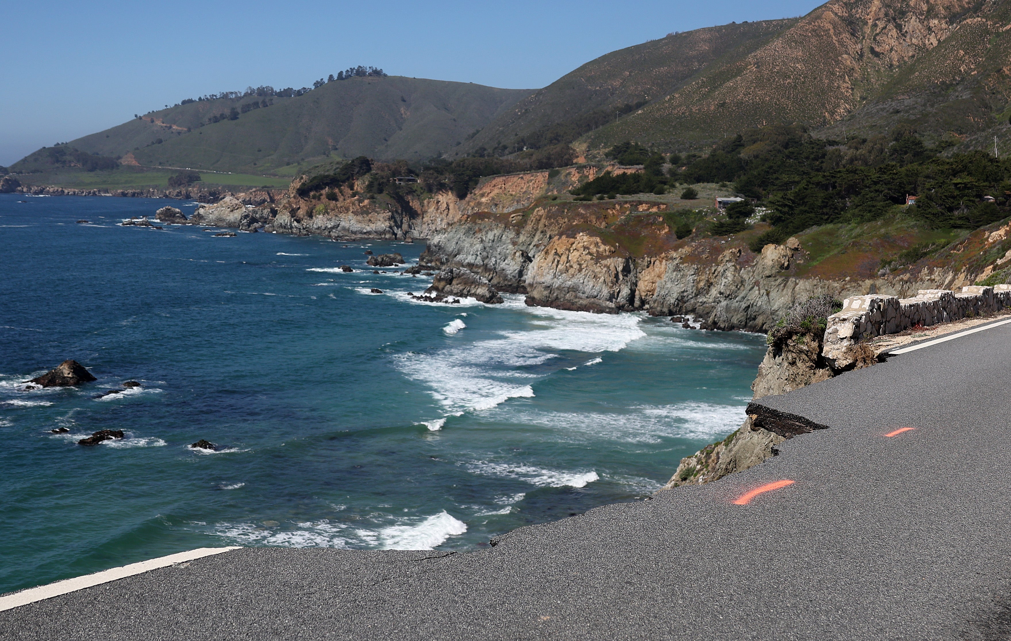 A hole is visible where a section of southbound Highway 1 broke off and fell in the ocean at Rocky Creek Bridge in 2024 following heavy rains, part of the destruction that spurred the revamp of the fabled higheway stretch