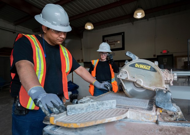 Silver Krinock, 21, center teaches student Edgar Martinez, 19, how to cut tile at Inland Empire Job Corps Center in San Bernardino on Tuesday, Aug. 16, 2022. This month, the Trump administration abandoned plans to terminate the program for young adults, ages 16-24. (Photo by Terry Pierson, The Press-Enterprise/SCNG)