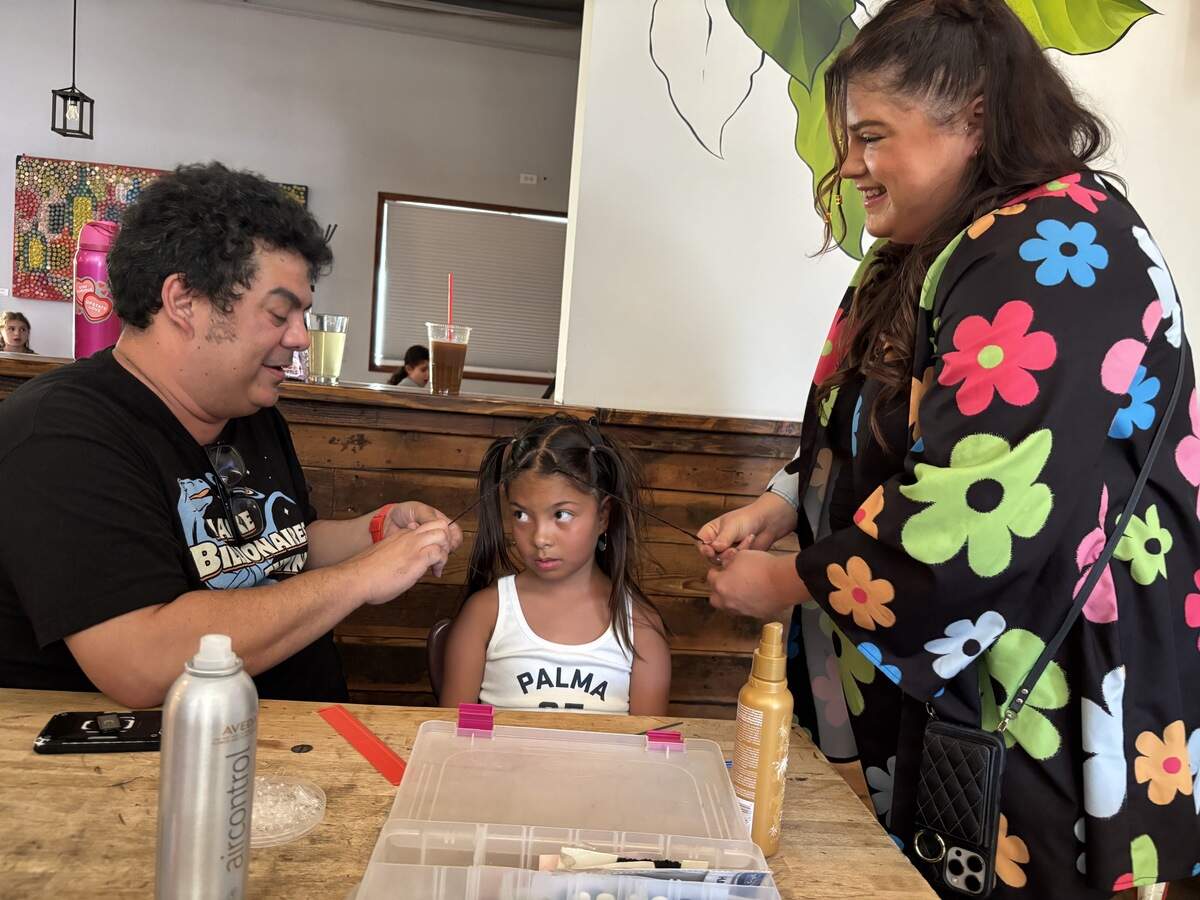 Hanibal Sonderegger and Strands Aveda hairstylist Allison Yanez put small braids at the front of Anina Sonderegger’s, 9, hair at the Pints and Ponies event at Nitty’s Cider in East Sacramento on Monday.