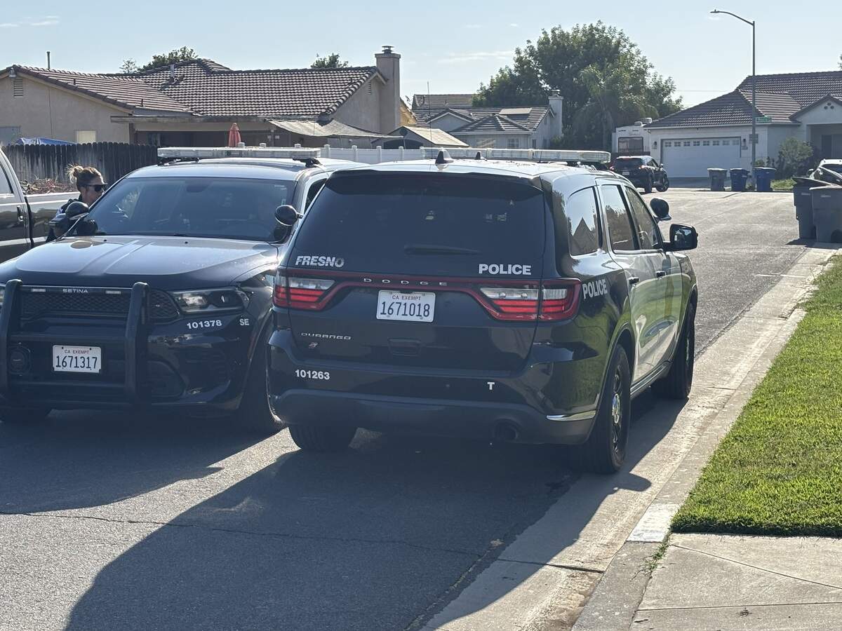 Fresno police vehicles at the E. Grove location after a death investigation at a home.