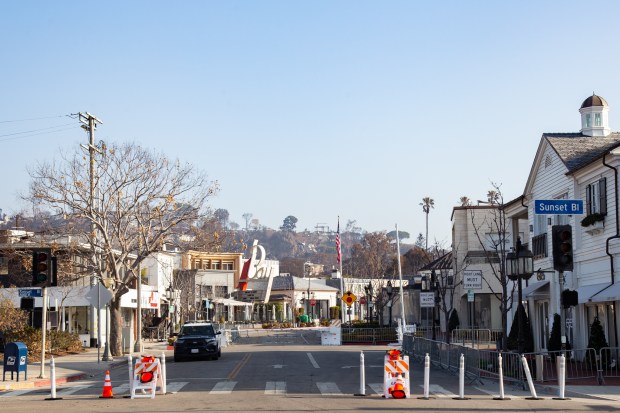 A police car guards access to the Village in Pacific Palisades in January 2025, which was largely spared by the fire by a private team of firefighters. (Photo by Jarret Liotta)