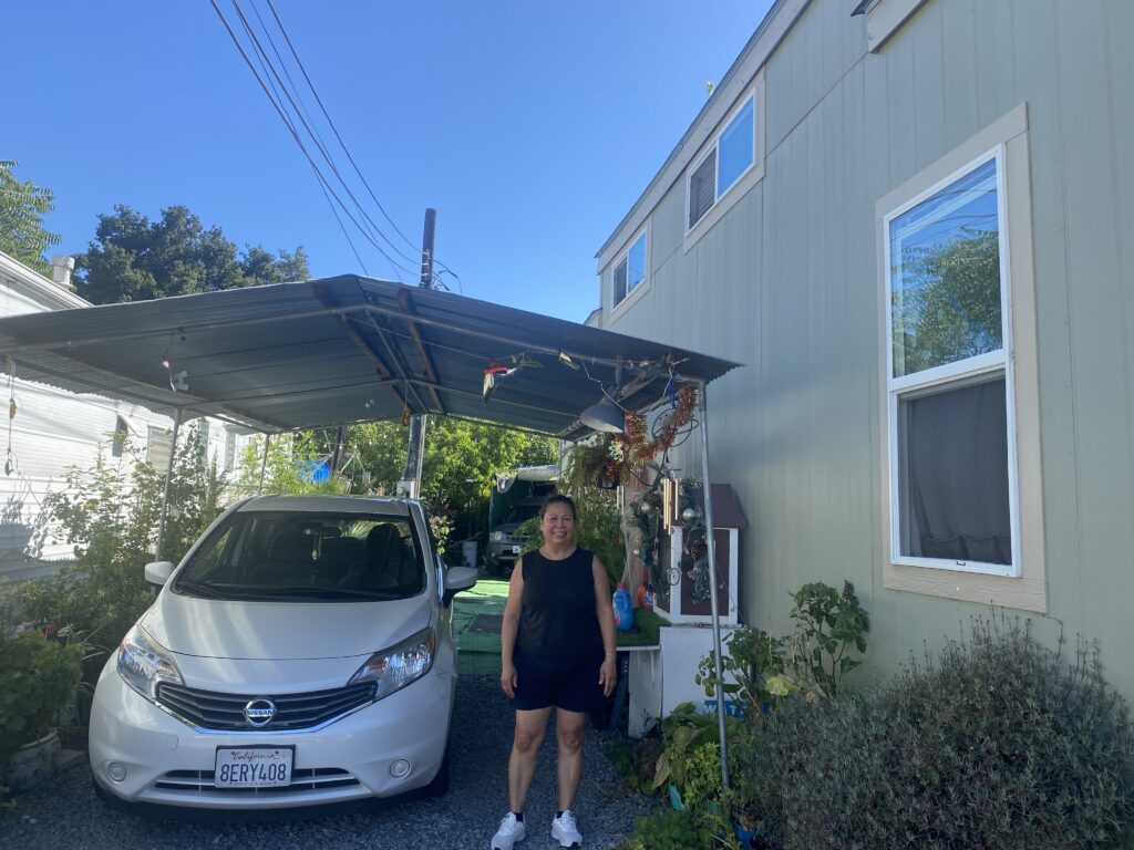 A woman standing next to a car at an rv park in San Jose, California