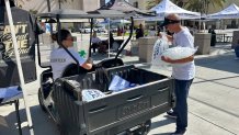 Volunteers kept a steady flow of ice bags moving across the Lincoln campus to help cool down families, August 1, 2026.