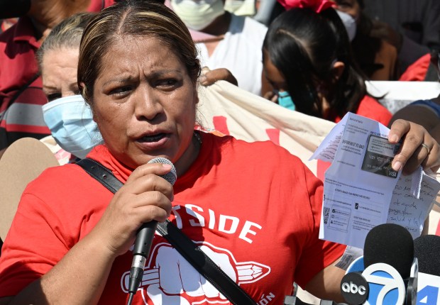Maria Lopez holds up a $1000 debit card given to her by Lineage. Residents of East L.A. and Boyle Heights held a press conference calling for the terminate shut down of Lineage on July 31, 2026 in Boyle Heights, CA. (Photo by John McCoy, Contributing Photographer)