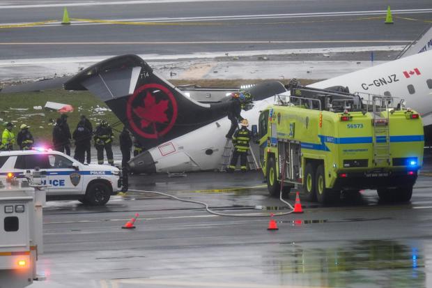 FILE - Firefighters and investigators examine the site, Monday, March 23, 2026, where an Air Canada jet came to rest after colliding with a Port Authority firetruck at LaGuardia Airport, after landing Sunday night in New York. (AP Photo/Seth Wenig, File)