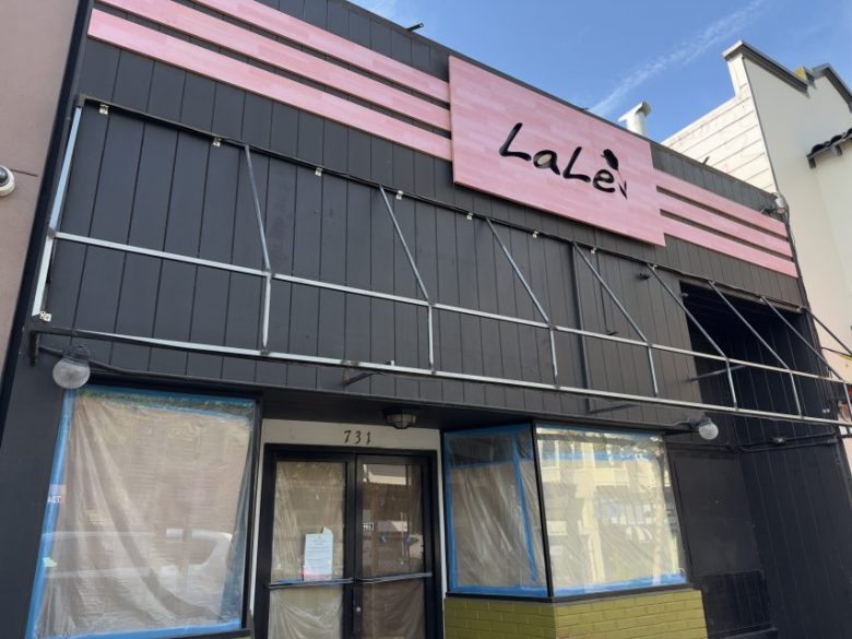 Storefront with a pink sign reading “LaLe” above black paneling, partially covered windows, and the number 731 above the door.