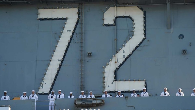 Sailors on the USS Abraham Lincoln man the deck as they wait to meet their families. Photo by Chris Stone