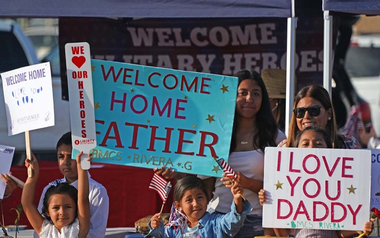 Families line a road on Naval Base North Island to greet family members aboard the USS Abraham Lincoln. Photo by Chris Stone