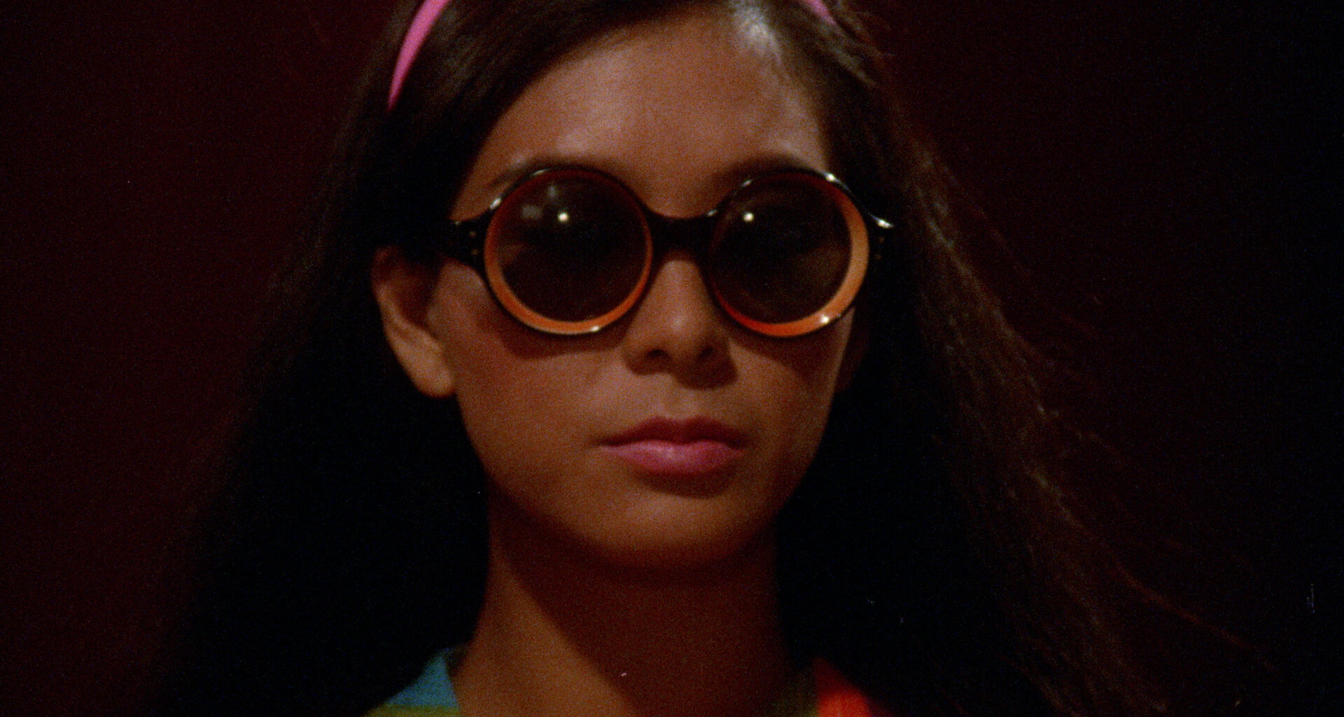 woman looks mysterious in round sunglasses