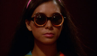 woman looks mysterious in round sunglasses