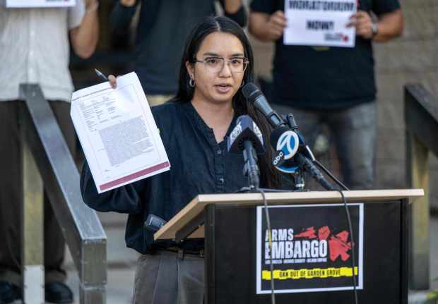Mai Nguyen Do, the Research and Policy Manager for the Harbor Institute for Immigrant and Economic Justice, holds up a copy of the "A History of Negligence at GKN Aerospace in Garden Grove" report, compiled by the GKN Out of Garden Grove Coalition, calling the company "a ticking time bomb," during a press conference in Garden Grove on Tuesday, August 25, 2026. (Photo by Jeff Antenore, Orange County Register/SCNG)