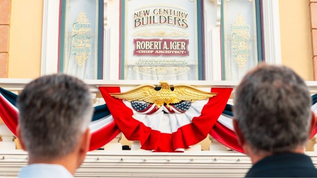 Current Disney CEO Josh D'Amaro, left, and former Disney CEO Bob Iger look at the New Century Builders window above the Emporium gift shop on Main Street USA at Disneyland. (Courtesy of Disney)
