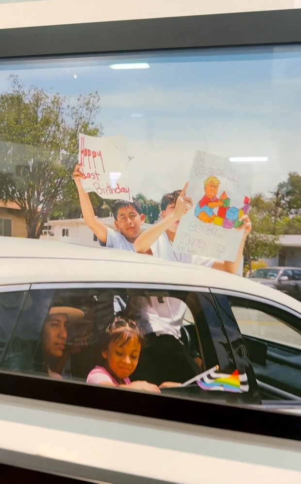 Screen grab from an X.com video posted by Wall Street Apes that shows a photo hanging at the OC Fair in Costa Mesa showing kids holding signs that read "Happy last Birthday" and "No Kings." The photo also has an caricature of President Donald Trump with the words, "You're not a king, so stop playing one" 