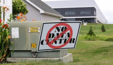 A small sign posted in a grassy front lawn says “no data center.”