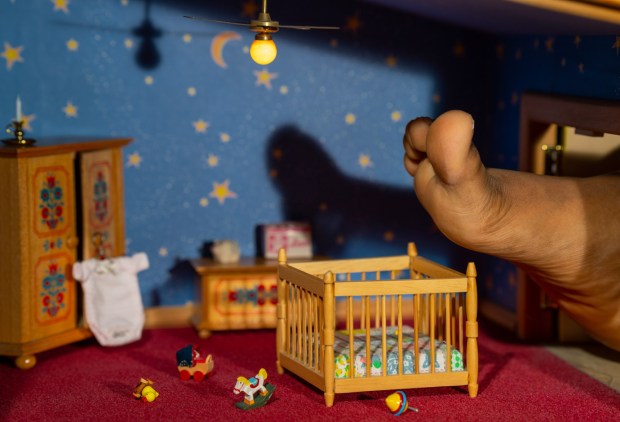 In a photo titled "Die Krippe" that is part of photographer Francesca Hummler's series "Our Dollhouse," the foot of her sister Masantu can be seen entering the dollhouse's nursery. (Francesca Hummler)
