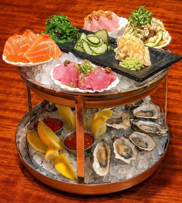 The Oceana Seafood Tower is a cold bar sampler with three different types of sashimi, tuna, yellowtail and salmon; Baja oysters on the half shell, cocktail shrimp, and both a sunomono and a seaweed salad. (Courtesy of Catamaran Resort Hotel and Spa)