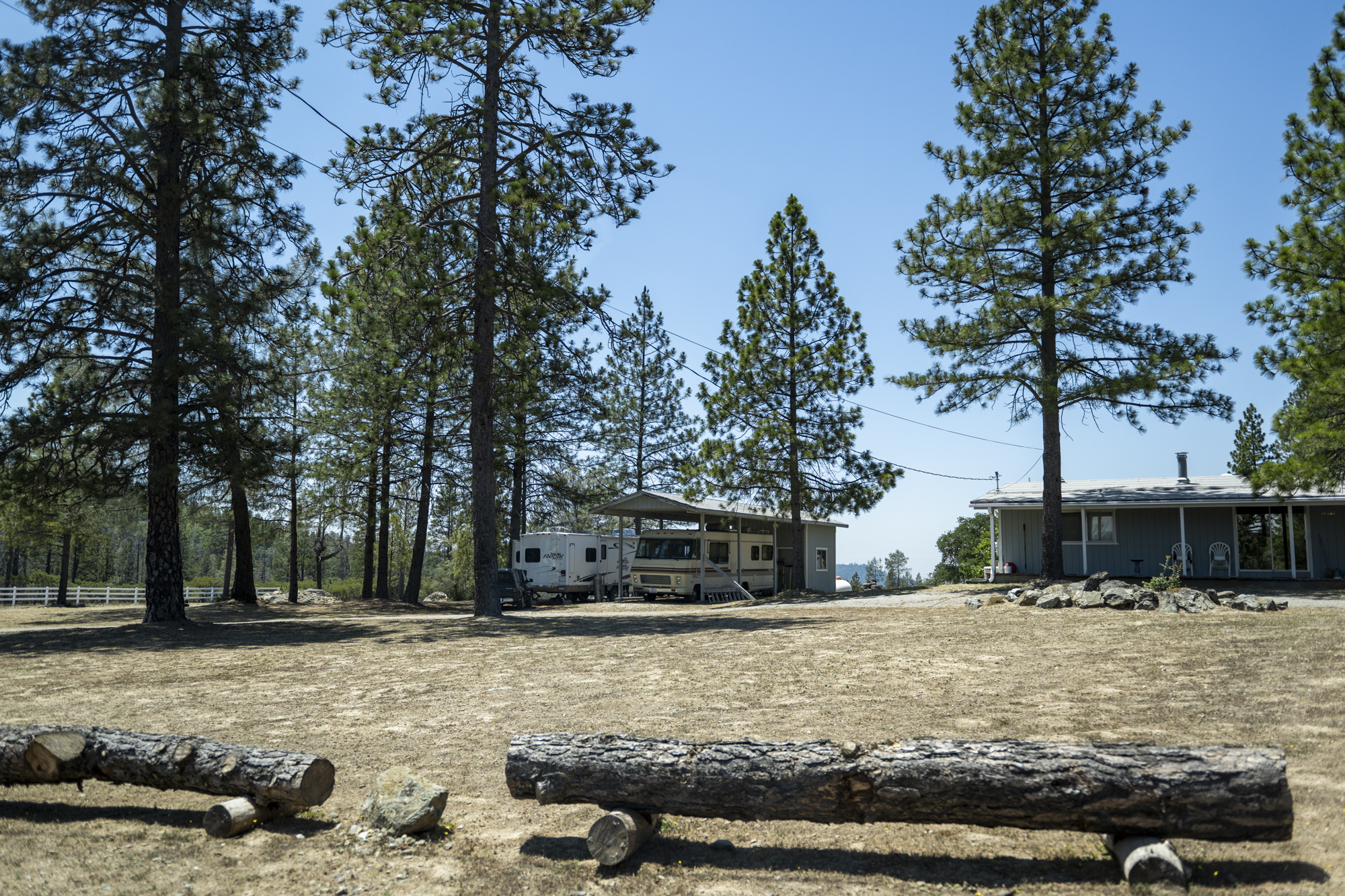Several homes and mobile homes sit on a hillsides where grasses have been removed.