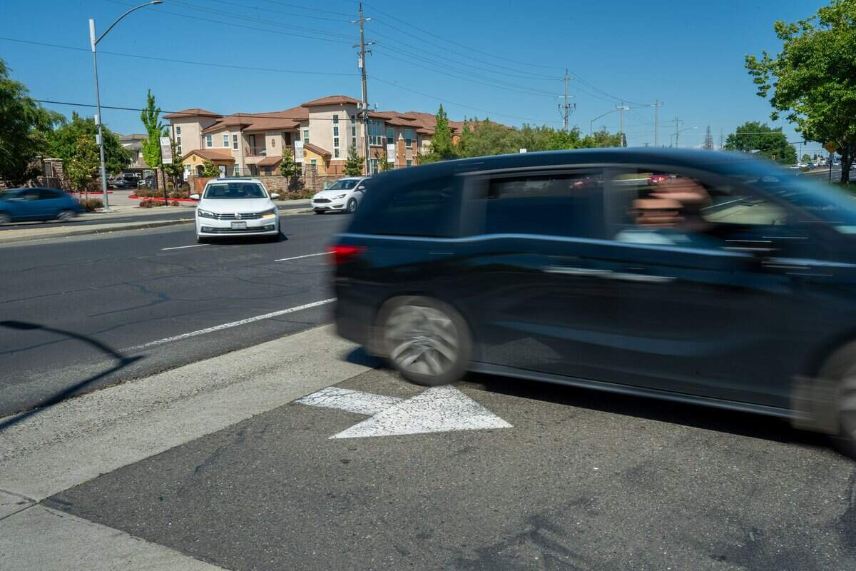 A passing motorist shouts, “Rest in Peace Connor,” and waves to Lopez’s family on April 29. Lopez’s family returns every week on the same day and hour to the intersection of Sheldon Road in Elk Grove where he was struck and killed while riding his motorcycle in 2025. Drivers regularly honk and wave to the family, who have been gathering near the intersection since his death.